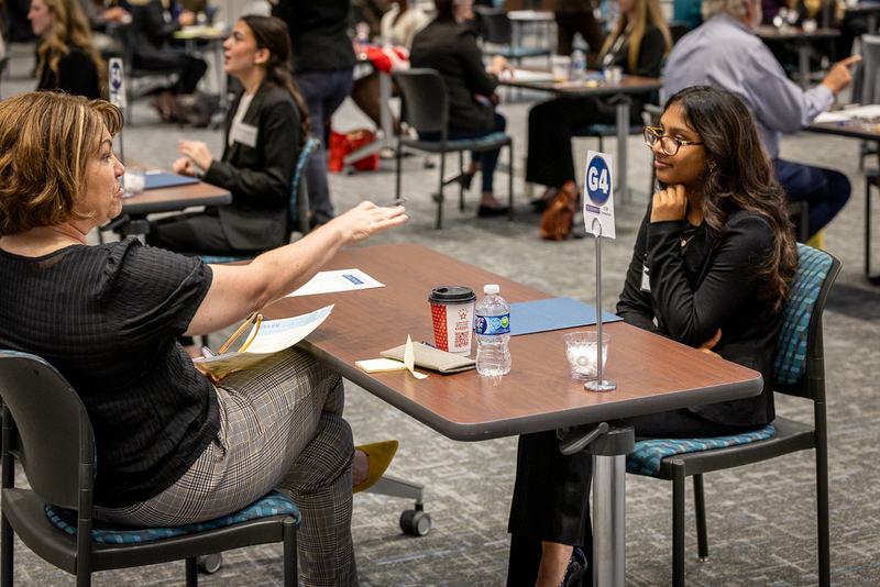 interviewer and female student seated at table during intervview