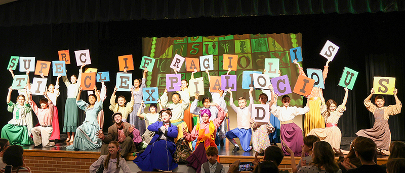 cast onstage performing a song