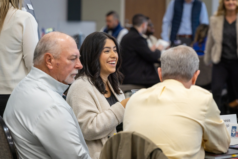 woman at table laughing during table discussion