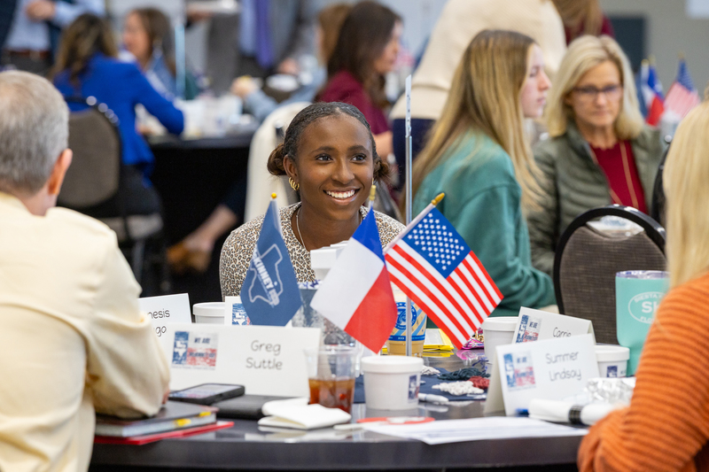 female african american high school student smiling at table during discussion
