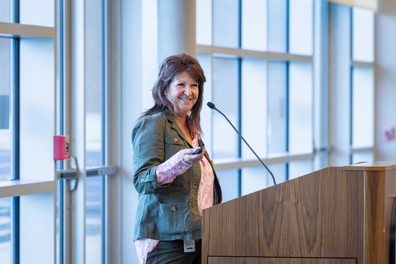 Errin French at podium smiling as she presents to the group