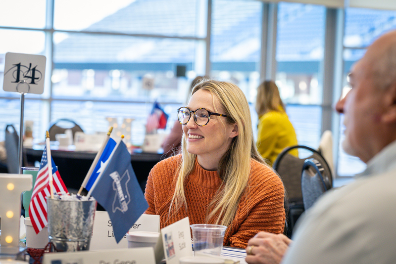 young woman smiling at table during group discussion