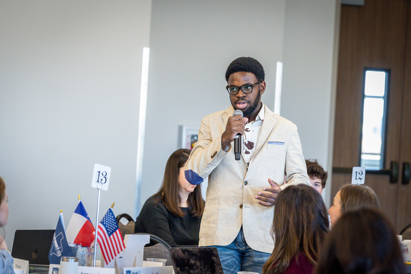 male african american student standing with microphone giving feedback during discussion