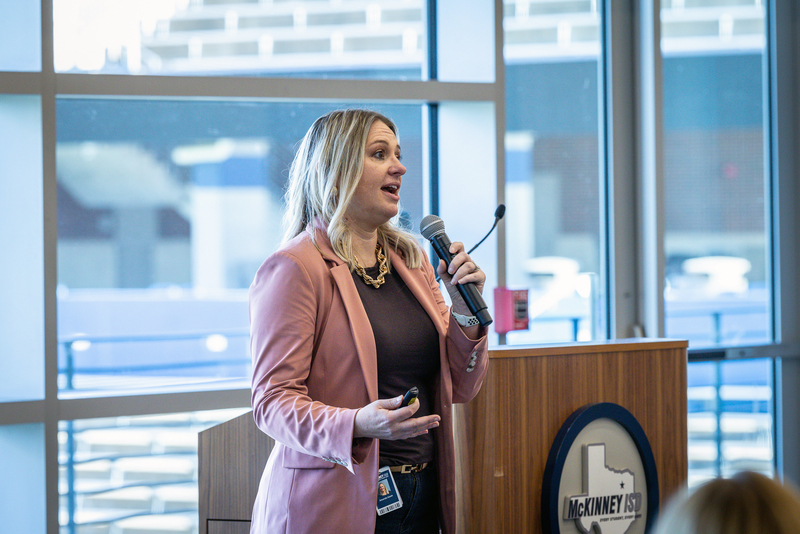 Amanda Gavin at front of the room holding microphone and speaking during presentation