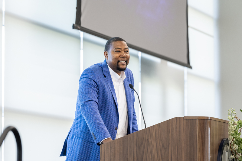 Wilson at the podium smiling as he speaks