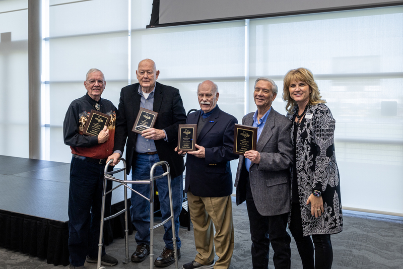 four members of the team holding award plaques with Jennifer Frazier