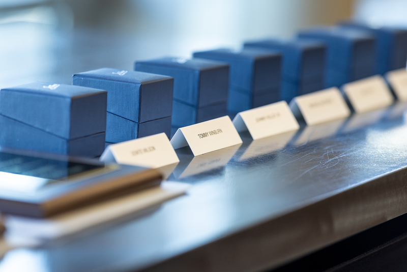 row of Hall of Honor rings in their boxes on a table on the stage with honorees names in front of them