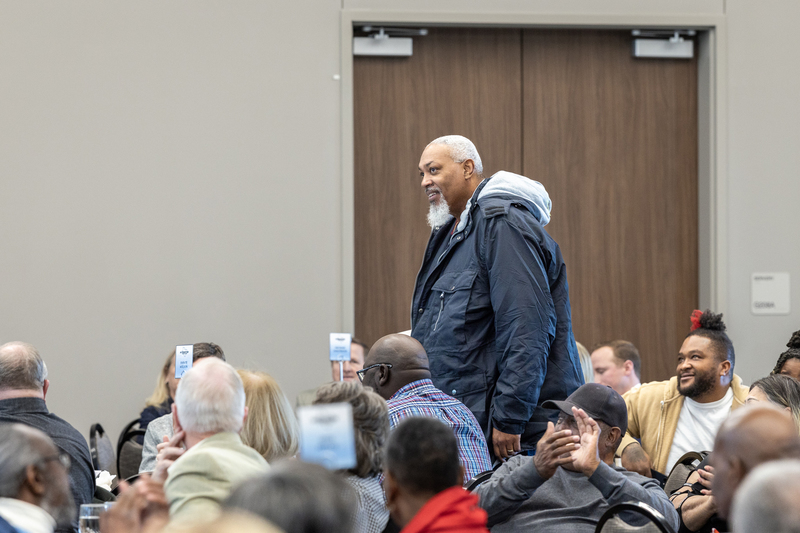 man standing during ceremony being recognized by speaker