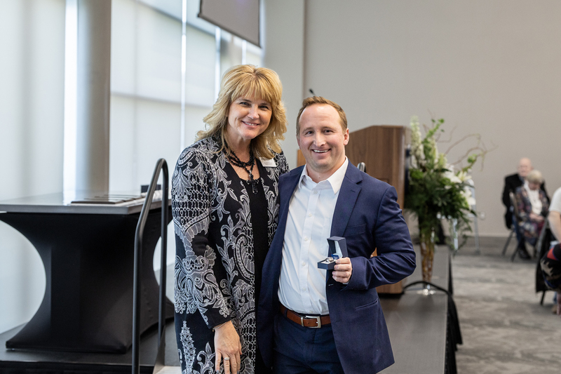 Michael Dauterive holding his Hall of Honor ring standing next to Jennifer Frazier