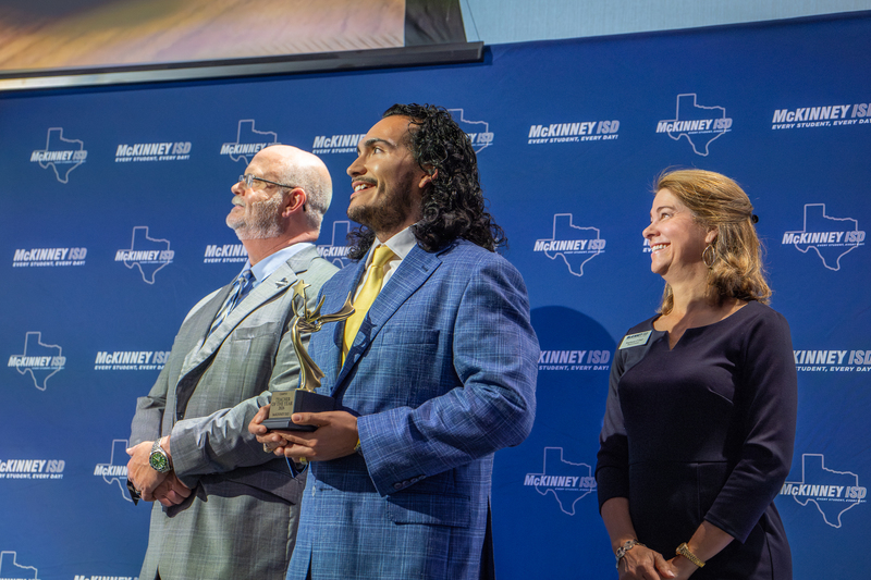 Baca onstage smiling and watching video