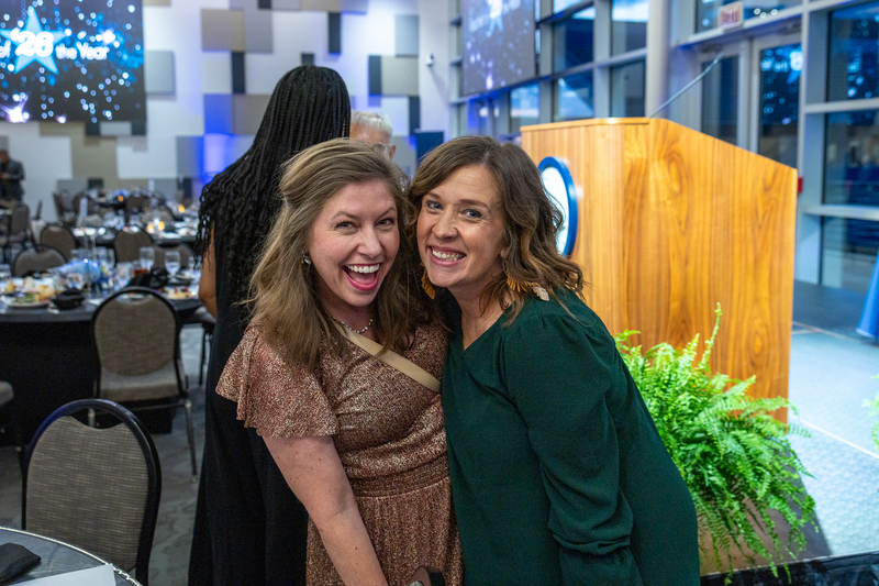 two female guests smiling and laughing at camera