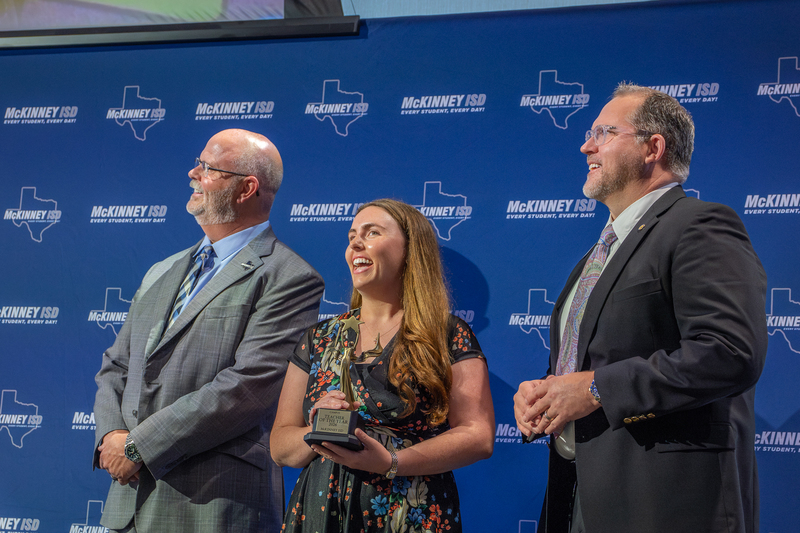 teacher on stage laughing at video