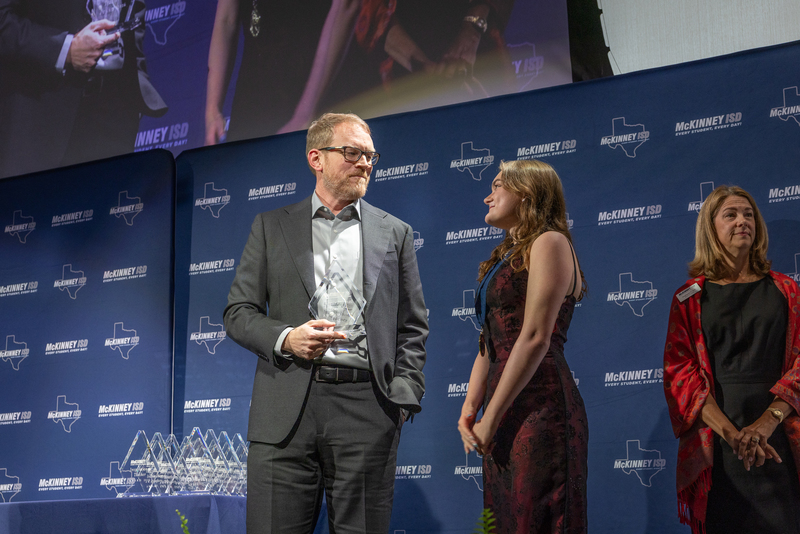 on stage with award