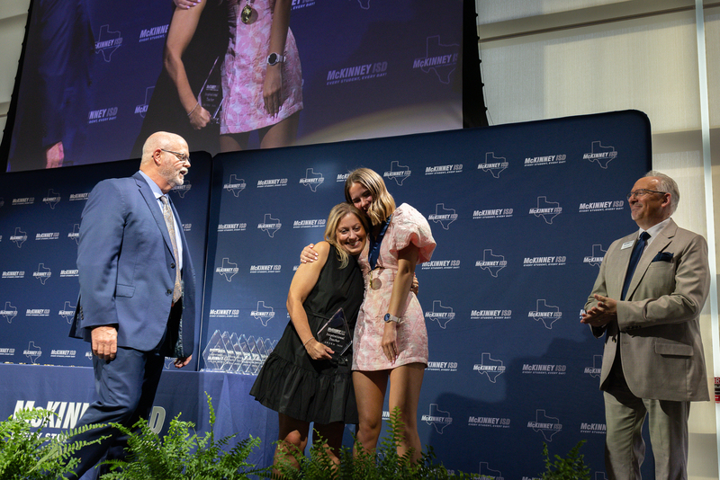 on stage with award