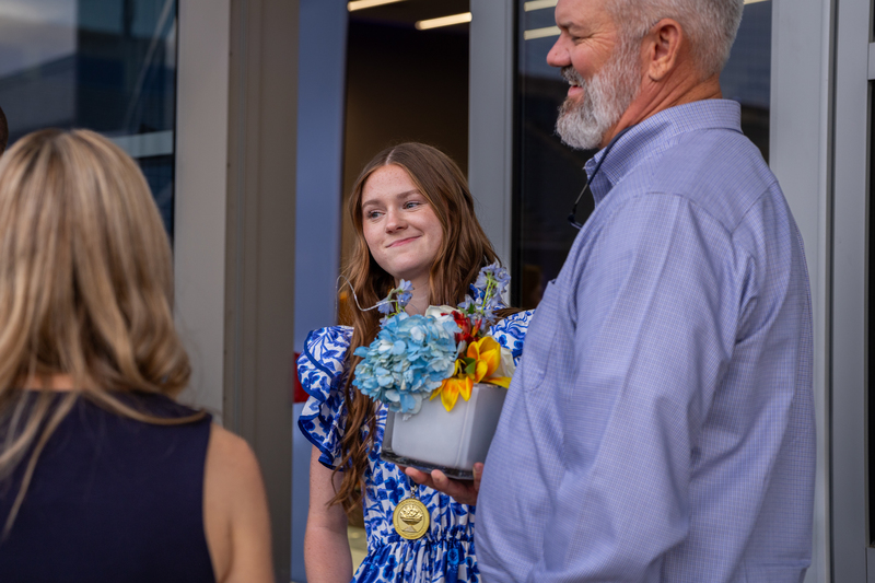 student with parents smiling