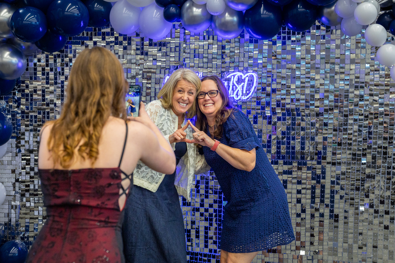 teachers in front of photo backdrop