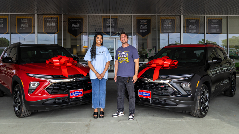 brannon and gillett in front of new cars