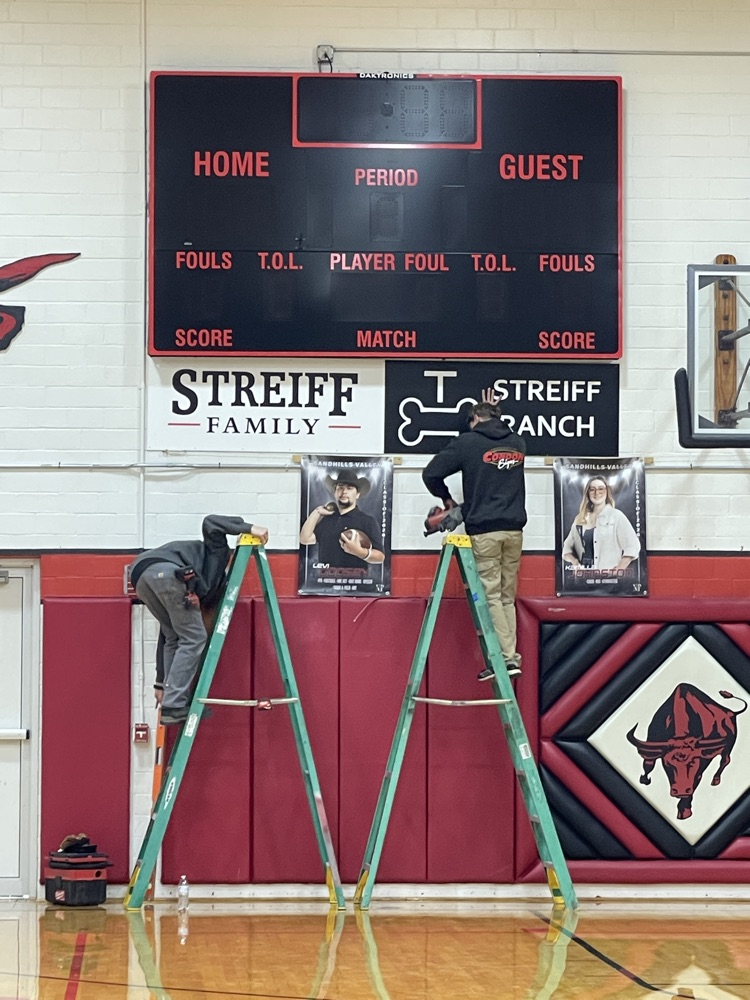 Installing signs under scoreboard .