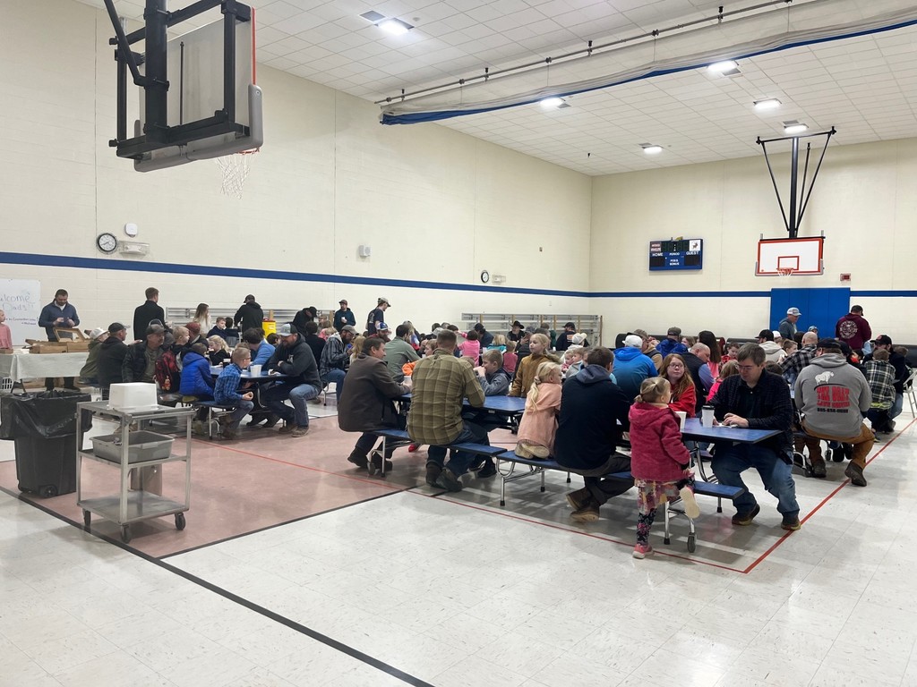 students and dads having donuts for donuts with dad 