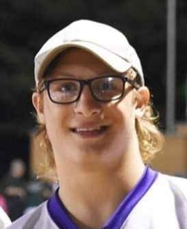 Jaron is wearing a white ball cap, black glasses and white /purple football jersey.