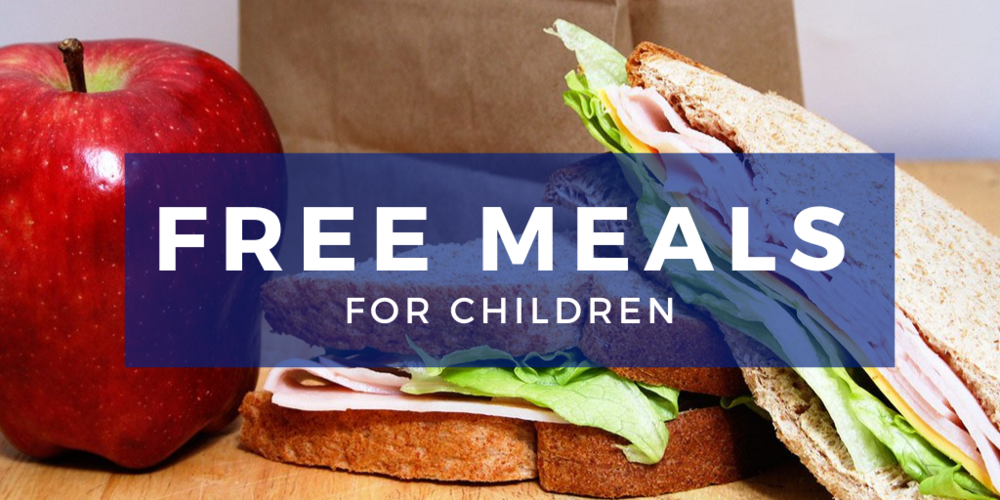 Free Meals for Children (white) written on a blue background. Then there is sandwich, brown paper bag and red apple in that background. This is sitting on a brown table