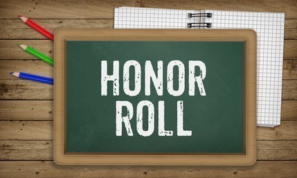 Honor Roll written chalk on a green chalk board with colored pencils and a graph paper around it.