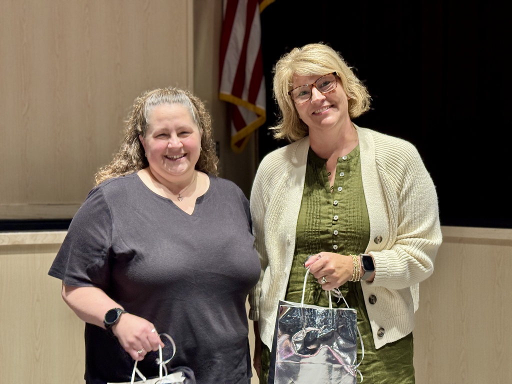 Two lades standing next to each other for a recognition photo