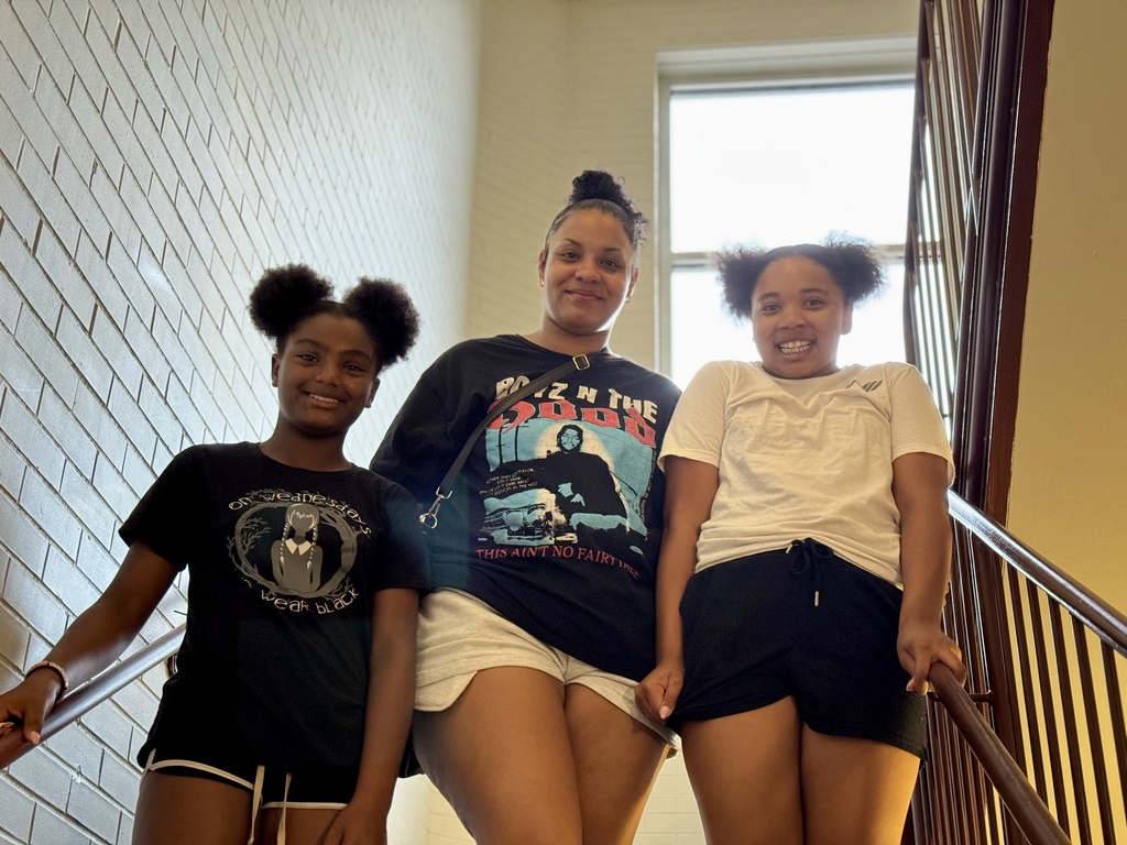 A family posing for a photo before heading upstairs during a school tour