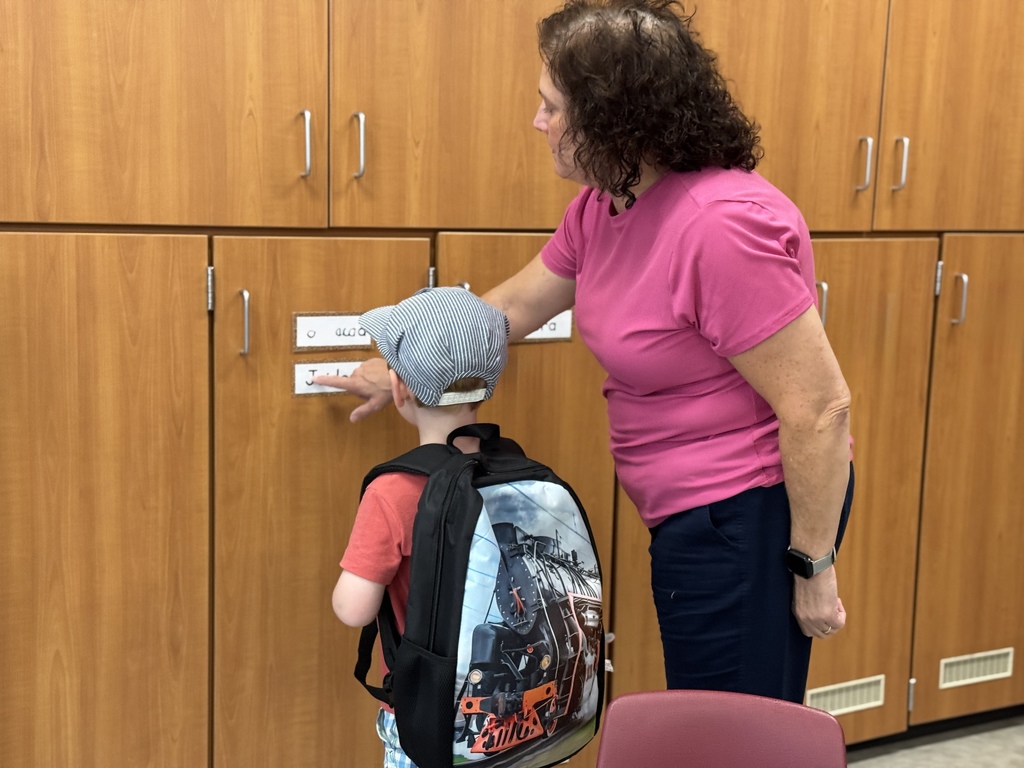 A young boy with a backpack finding his cubby in his classroom