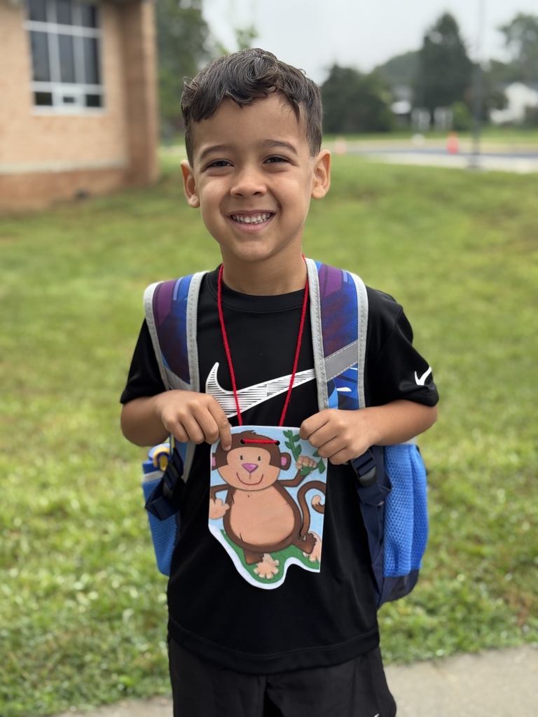 Smiling boy on first day of school. He's wearing his backpack.