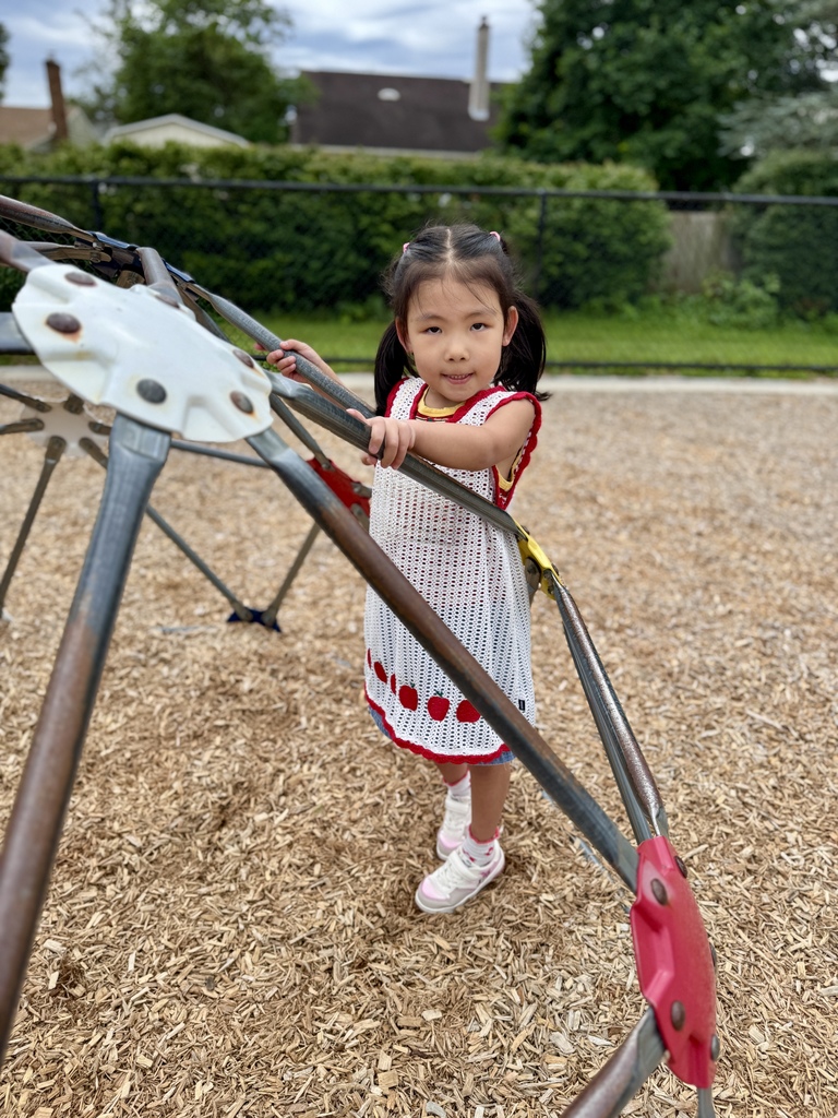Girl standing in the middle of a set of monkey bars