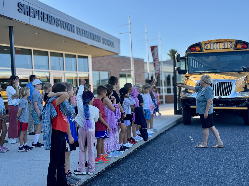 Bus driver talks to students before boarding school bus