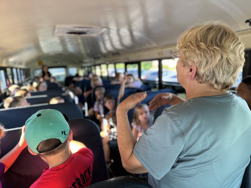 Bus driver talks to bus of students