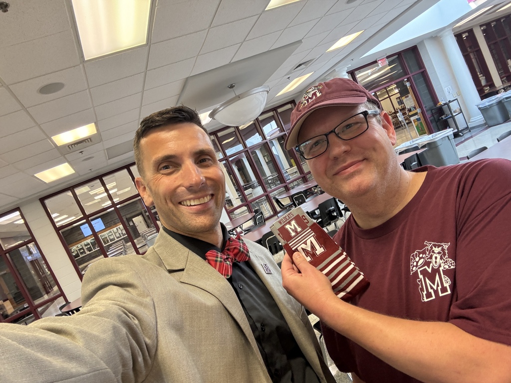 Selfie of two men holding a pair of branded socks