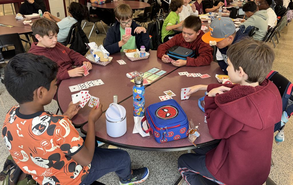 Students playing a card game at lunch