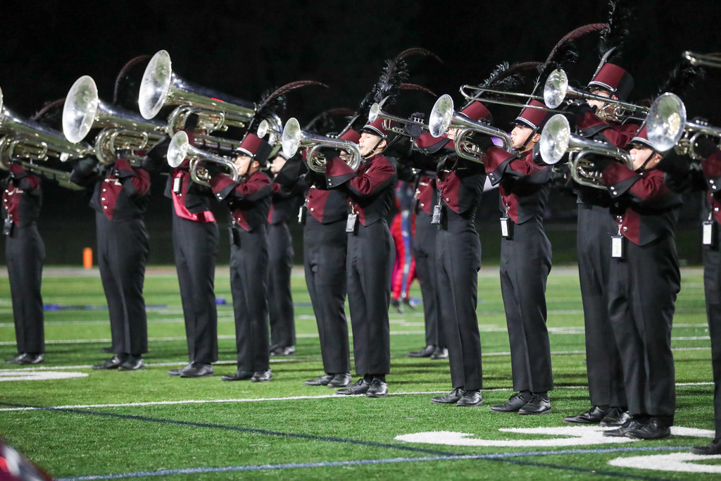 A high school marching band performing during a football game.