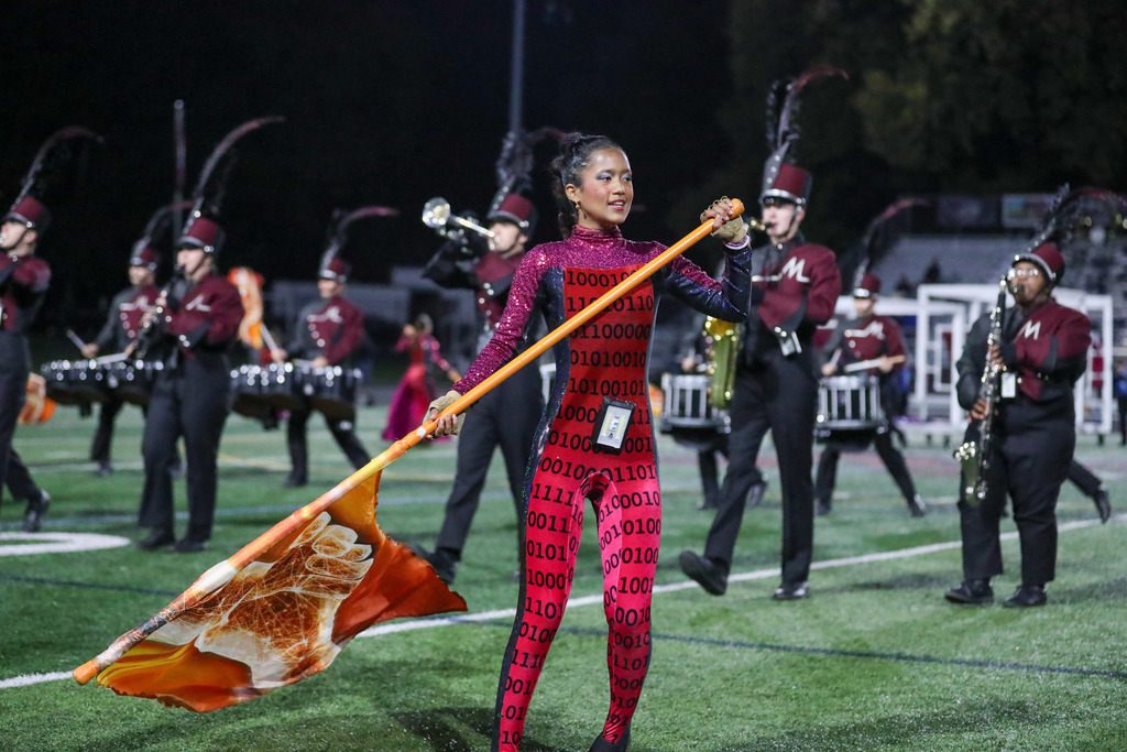A high school marching band performing during a football game.