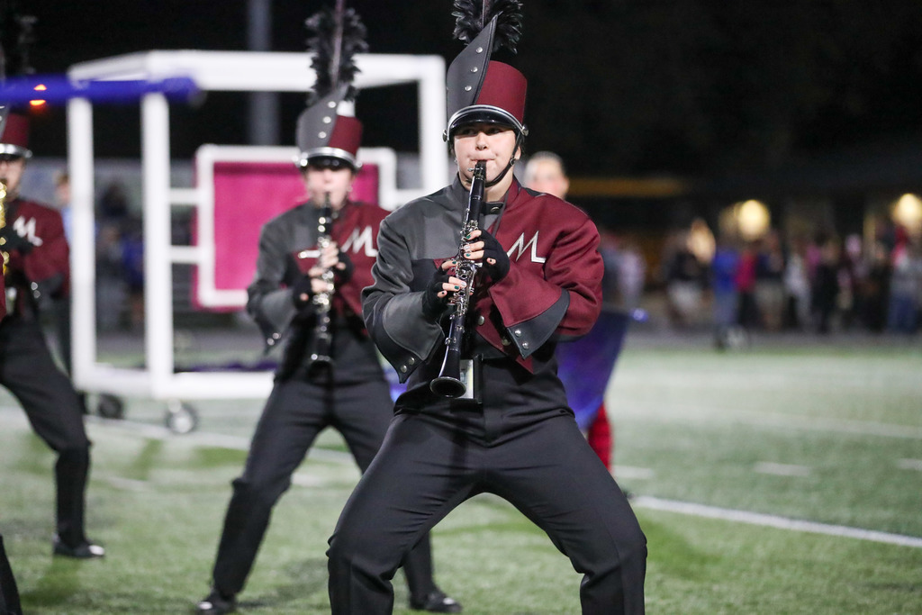 A high school marching band performing during a football game.