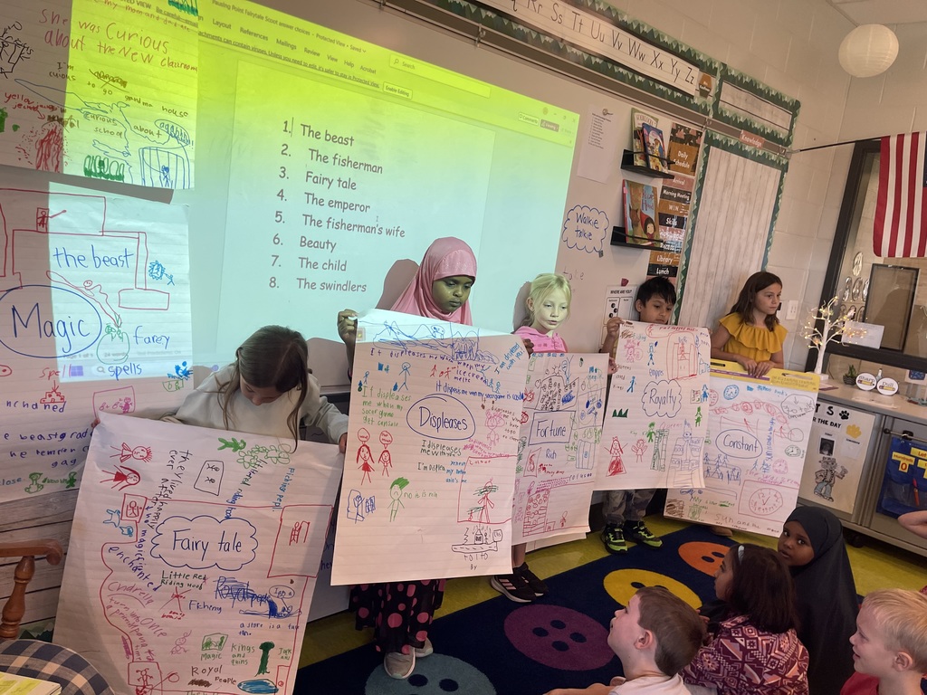 Students holding large chart paper full of their writings
