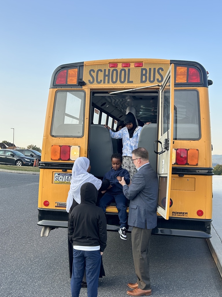 Students practicing how to safely exit the back of a  school bus in an emergency.