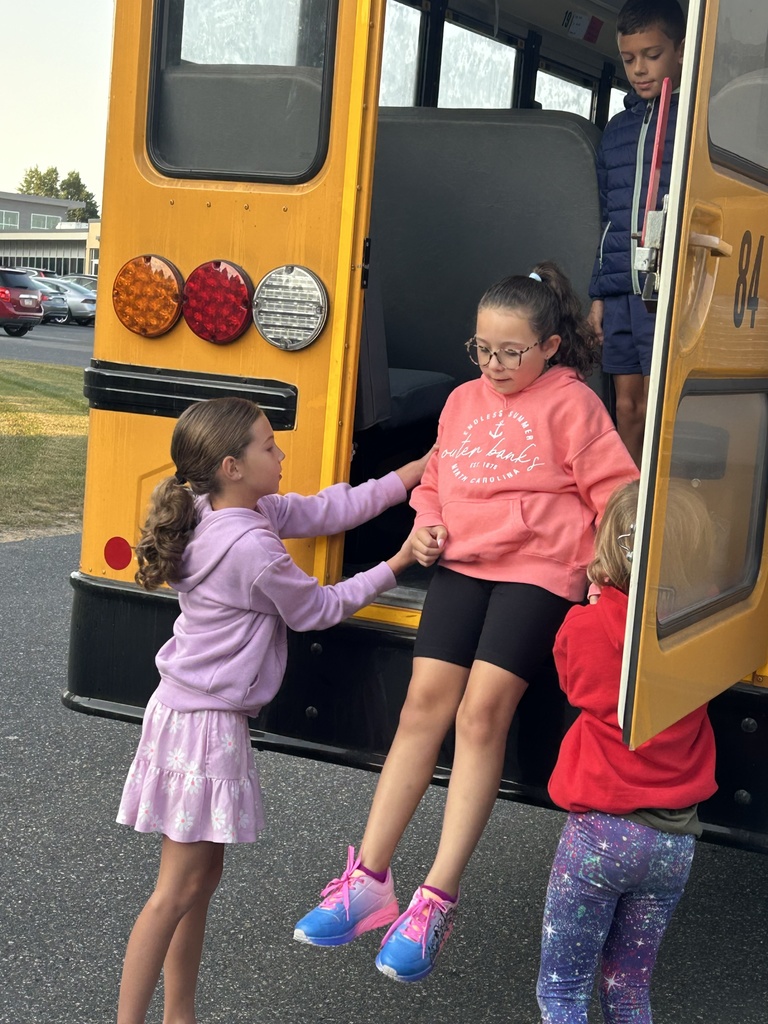 Students practicing how to safely exit the back of a  school bus in an emergency.