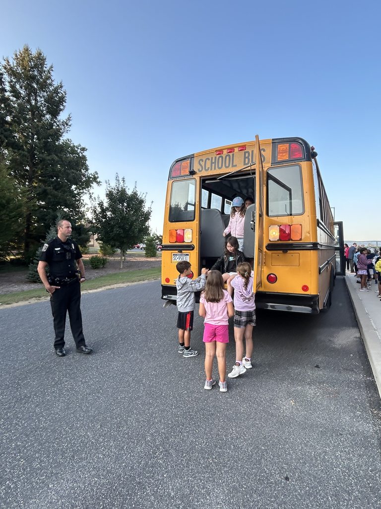 Students practicing how to safely exit the back of a  school bus in an emergency.