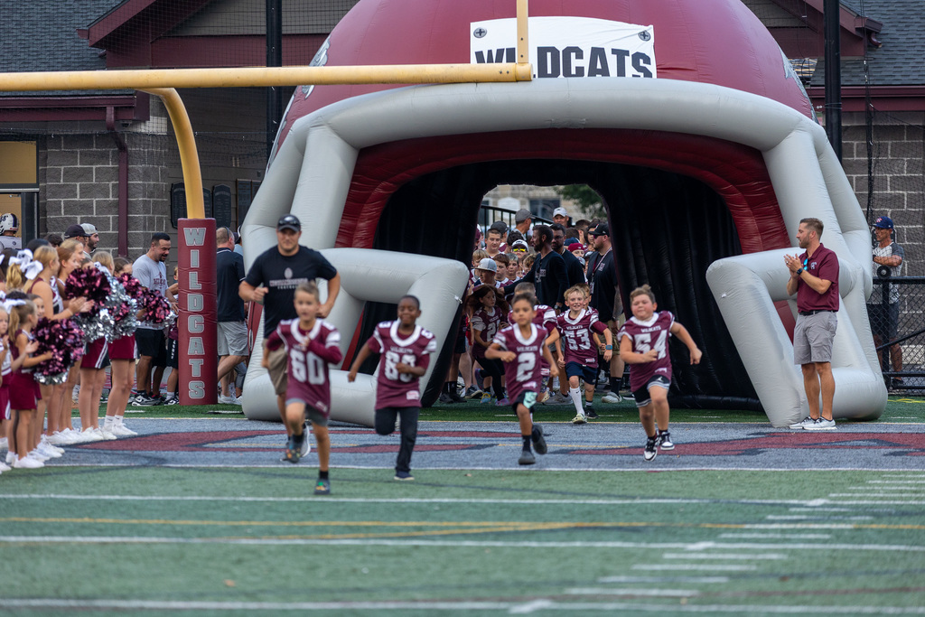 youth football players running onto the field