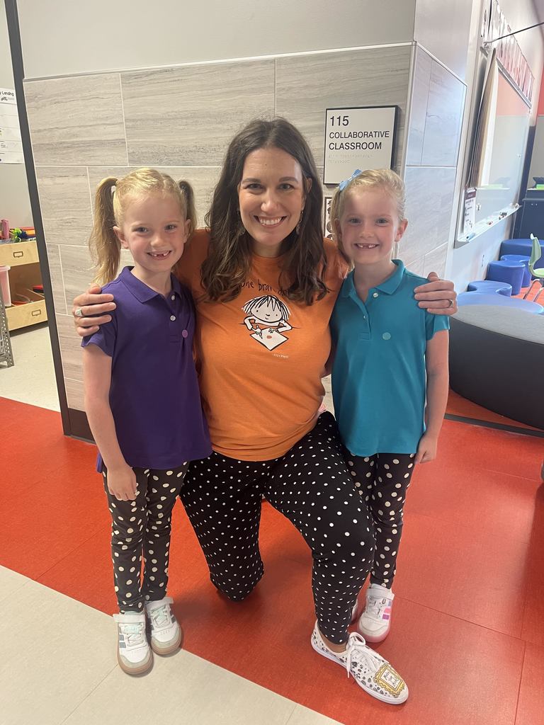 Two students and a teacher showing off matching black and white polka dot pants
