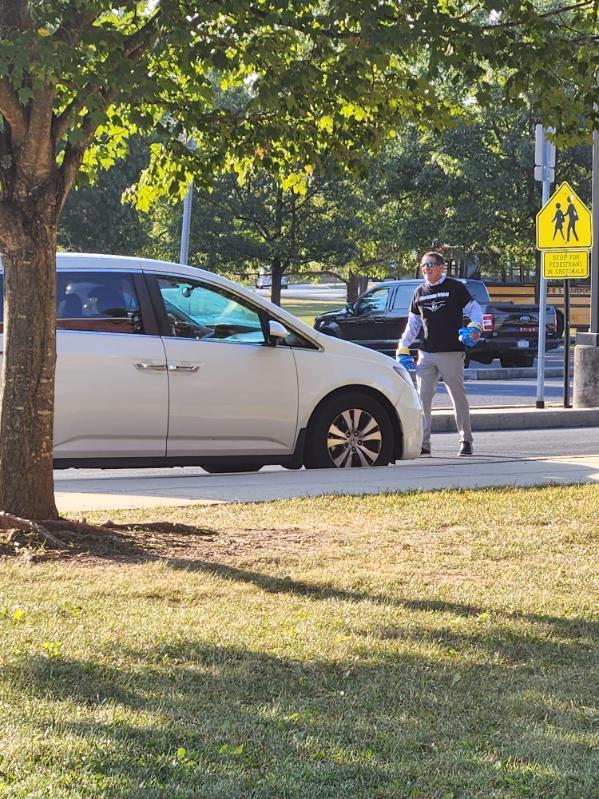 A principal giving high fives in the car line