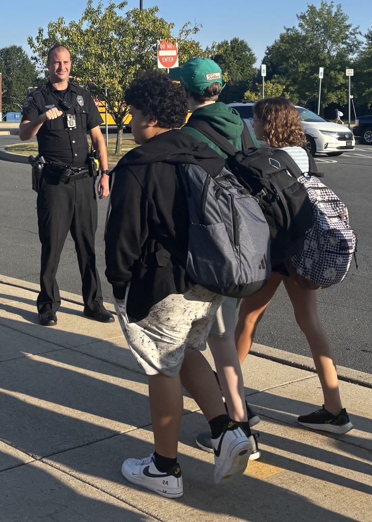 A police officer giving fist bumps to students.