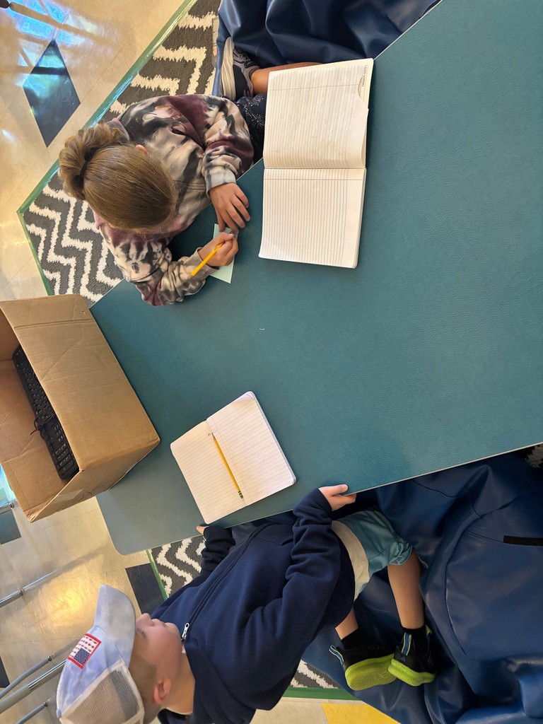 Student writing on a blue notecard