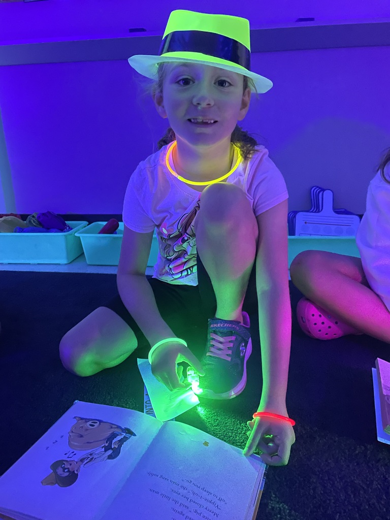 Student wearing glow in the dark hat and necklace