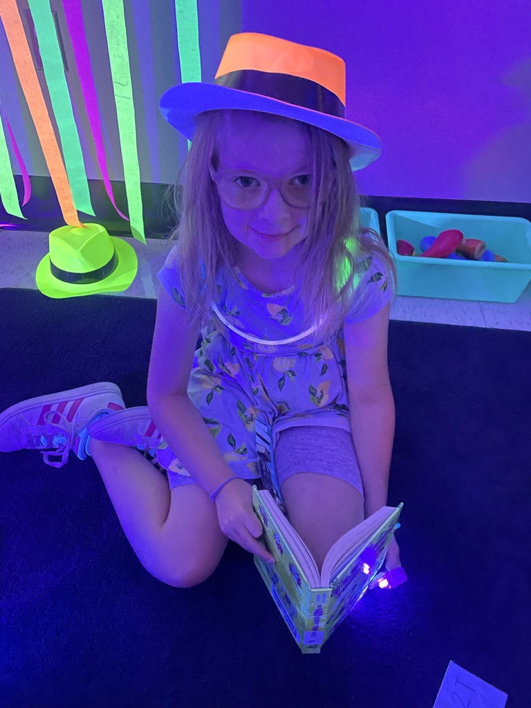 Student wearing glow in the dark hat and necklace