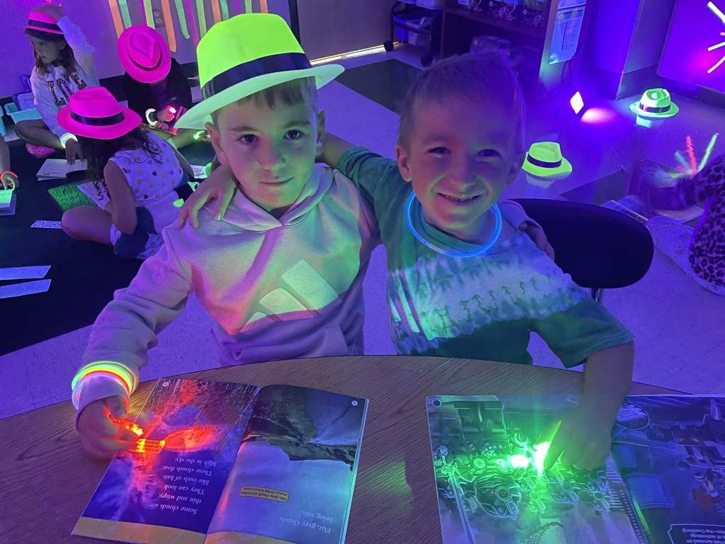 Students reading with glow in the dark finger lights